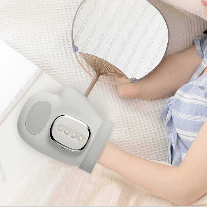 Person using a handheld electronic device on their arm with a fan and table in the background