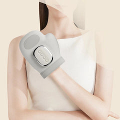 Person using a gray electronic device on their arm against a beige background